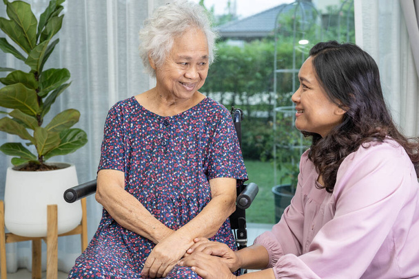Help and care Asian senior or elderly old lady woman patient sitting on wheelchair at nursing hospital ward, healthy strong medical concept - Photo, Image