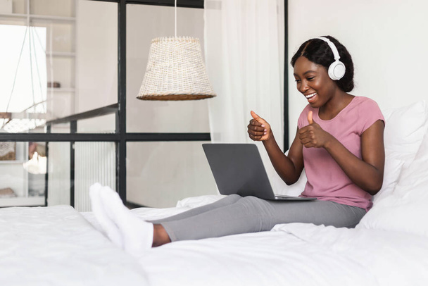 Vreugdevolle Afro-Amerikaanse vrouw video aanroepen op laptop thuis - Foto, afbeelding