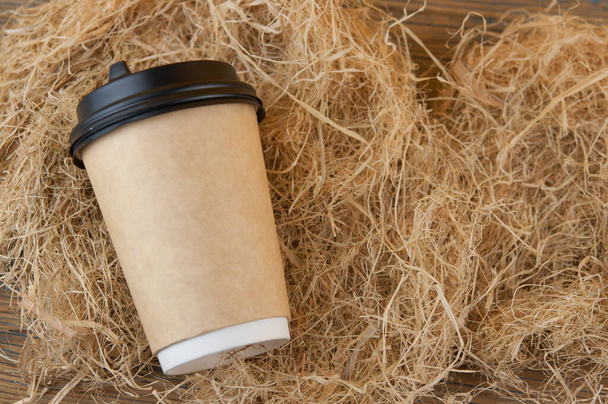 eldobható kávés csésze kávé szalma alapon. Felülnézet - Fotó, kép
