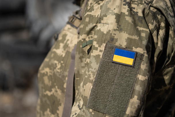 Bandera ucraniana con uniforme militar, guerra. Soldado de las Fuerzas Armadas de Ucrania. Defensa territorial. Macro - Foto, imagen