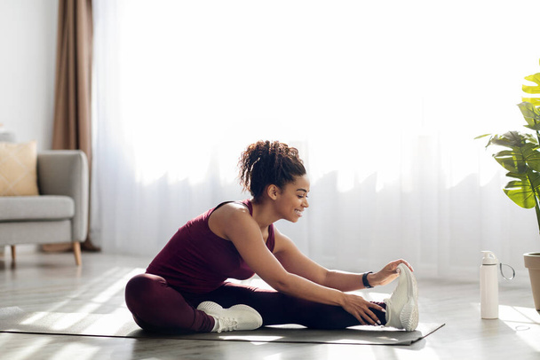 Active african american woman stretching at home - Valokuva, kuva