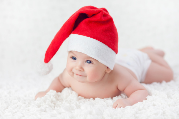 Дитина лежить у різдвяній шапці
 - Фото, зображення