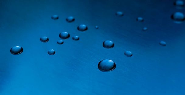 drops of water on a shiny baking sheet - Фото, изображение