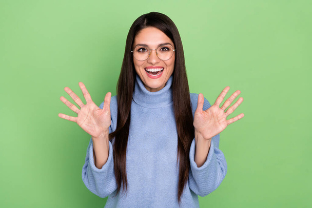 Photo of hooray young brunette lady arms up wear blue pullover isolated on green color background - Photo, image