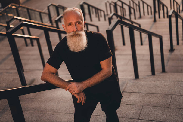 Fénykép komoly koncentrált nyugdíjas edző edző állni erős lépcső viselni póló városi város szabadban - Fotó, kép