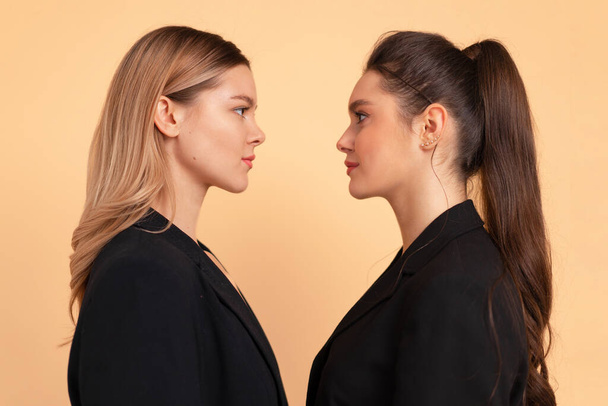 Two business woman facing each other face to face eyes to eyes friends business competition with partner concept. 2 caucasian female business person looking each other in face. Coworker confrontation - Foto, Imagem