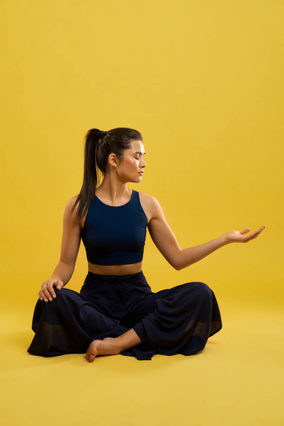 Woman wearing blue sport suit, doing yoga. - Fotoğraf, Görsel