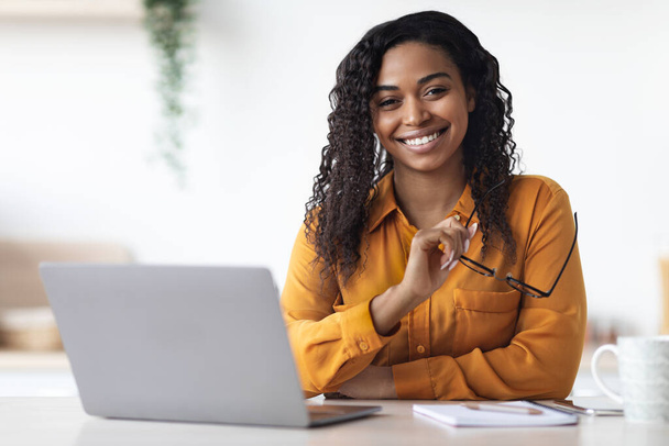 Csinos afro-amerikai nő szabadúszó használ laptop otthon - Fotó, kép