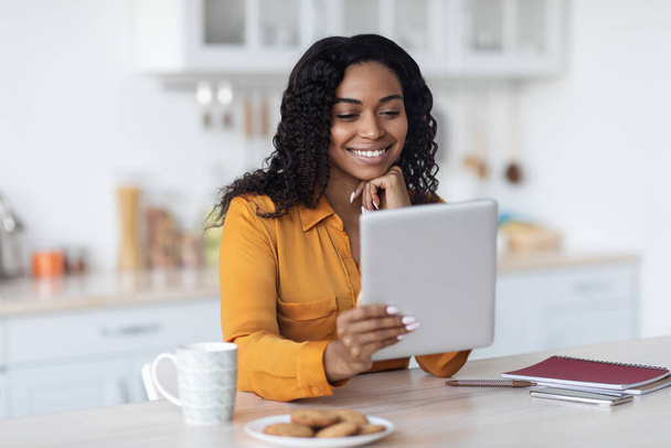Happy black woman using digital tablet and having coffee break - Foto, imagen
