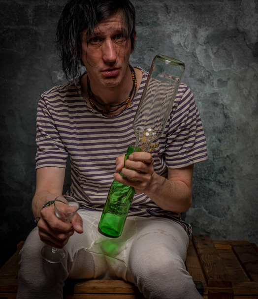 sujo preto cabelo homem com álcool copos e garrafas e idade pedra escuro parede - Foto, Imagem