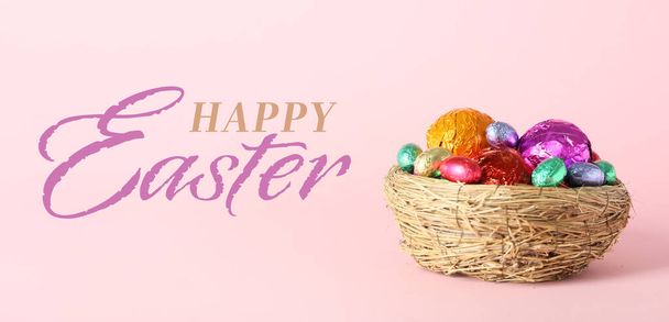 Renkli çikolata yumurtalı yuva ve pembe arka planda Mutlu Paskalyalar - Fotoğraf, Görsel
