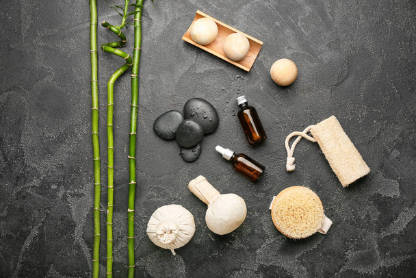 Composición del spa con artículos de baño, aceite esencial y piedras sobre fondo oscuro - Foto, imagen