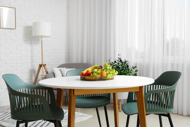 Dining table with fruit basket in light room - Photo, Image