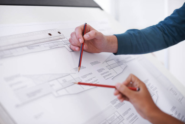 Its all about precision. Cropped shot of two architects working on a building plan at a drawing board. - Photo, Image