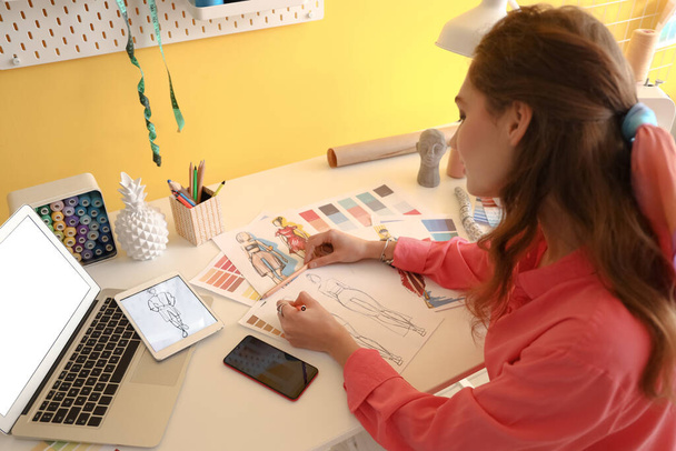 Jovem estilista de roupas femininas trabalhando em estúdio - Foto, Imagem
