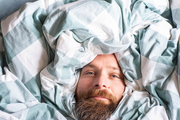 happy relaxed man portrait sleeping in duvet - Photo, Image