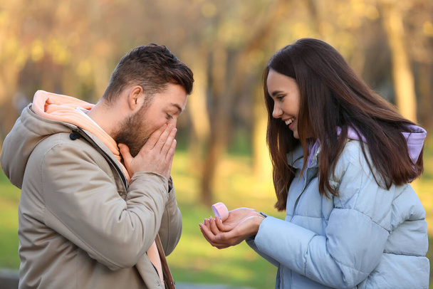 Jeune femme demandant en mariage à son petit ami surpris dans la forêt - Photo, image