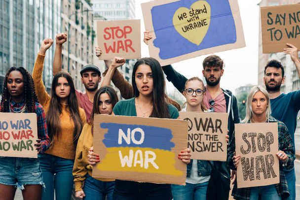 menigte jongeren staan voor vrede - demonstranten met besturen tegen oorlog  - Foto, afbeelding