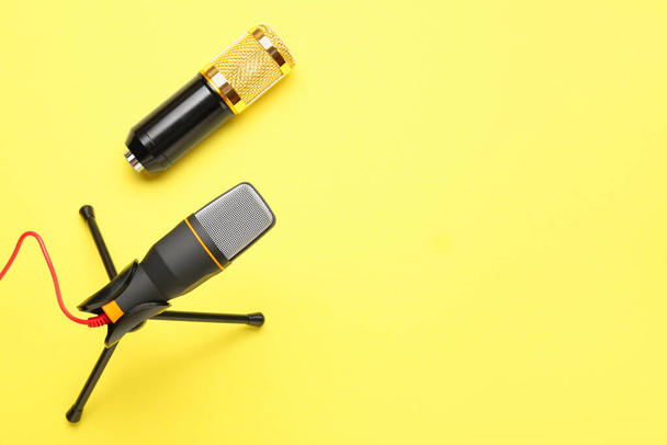 Modern microphones with stand on yellow background - Photo, Image