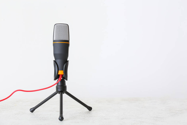 Stand with modern microphone on light background - Foto, Imagem
