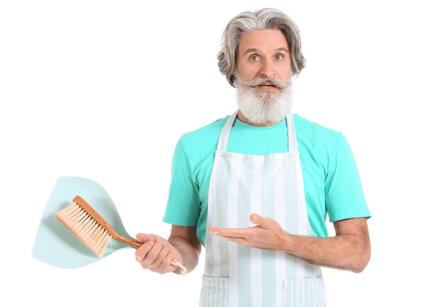 Ανώτερος άνθρωπος με σέσουλα και βούρτσα καθαρισμού σε λευκό φόντο - Φωτογραφία, εικόνα