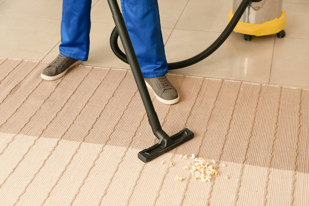 Male worker cleaning trendy carpet in room, closeup - Foto, immagini