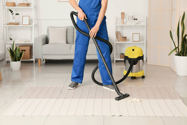 Travailleur masculin nettoyage tapis tendance dans la chambre - Photo, image