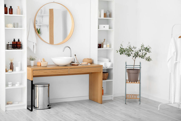 Стильний інтер'єр ванної кімнати з полками і столом з різними приладдям для ванни
 - Фото, зображення