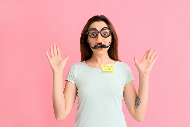 Young woman in funny disguise on pink background. April fools' day celebration - Foto, Bild