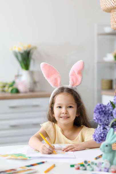 Linda niña con orejas de conejo pintura en la víspera de Pascua en casa - Foto, Imagen
