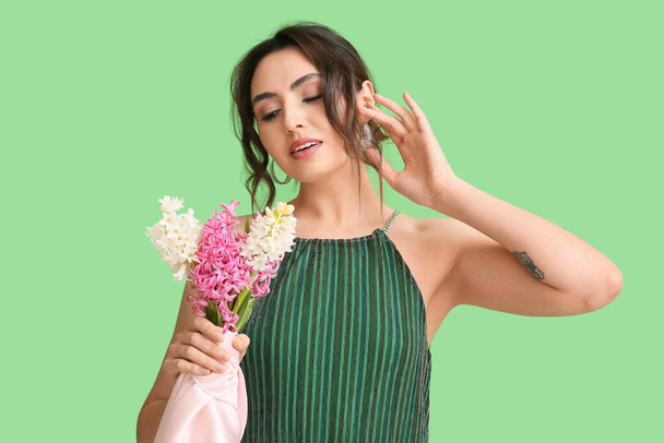 Красивая девушка с гиацинтовыми цветами на зеленом фоне - Фото, изображение
