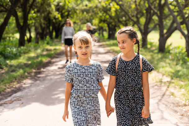 Two happy school girls in the park - Fotoğraf, Görsel
