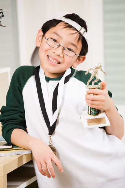 winnende jongen met zijn medaille en trofee - Foto, afbeelding