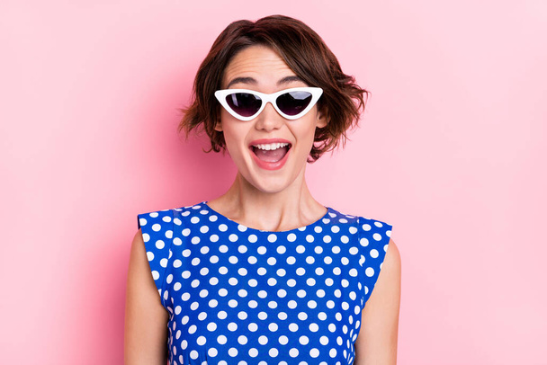 Photo of impressed millennial brunette lady wear eyewear blue top isolated on pink color background - Foto, afbeelding