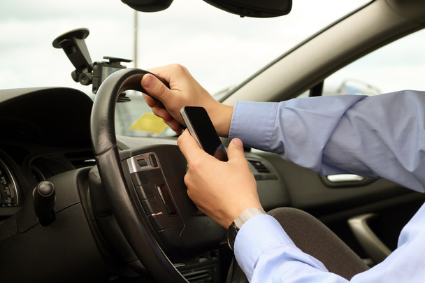 chaleira usando telefone inteligente móvel durante a condução do carro
 - Foto, Imagem