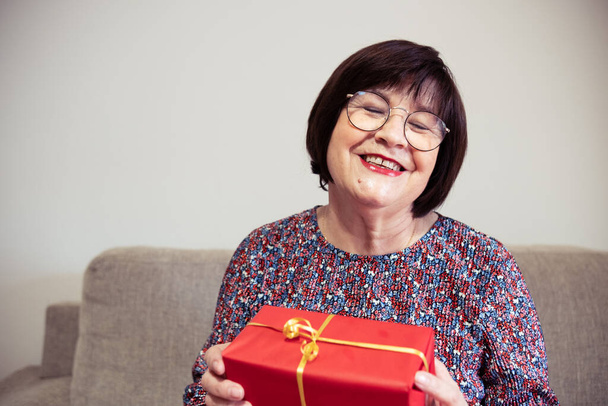 La donna più anziana sorridente è felice del regalo ricevuto - Foto, immagini