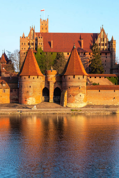 Malbork, Polsko - 22. března 2022: Středověké hlavní město teutonských rytířů, gotický cihlový hrad Malbork v Polsku. Oblíbená turistická atrakce a památka UNESCO - Fotografie, Obrázek