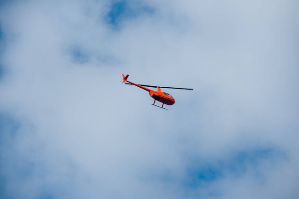 helikopter az égen kék ég piros narancs helikopter repül nyáron - Fotó, kép