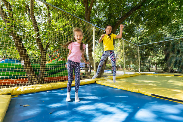 Les jeunes enfants caucasiens sautent sur un trampoline. - Photo, image
