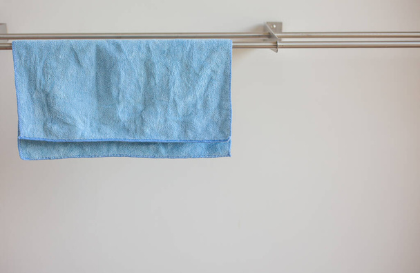 Foto de cerca de un paño de microfibra azul para limpiarlo y secarlo en el estante de secado. Paño para la limpieza. - Foto, imagen
