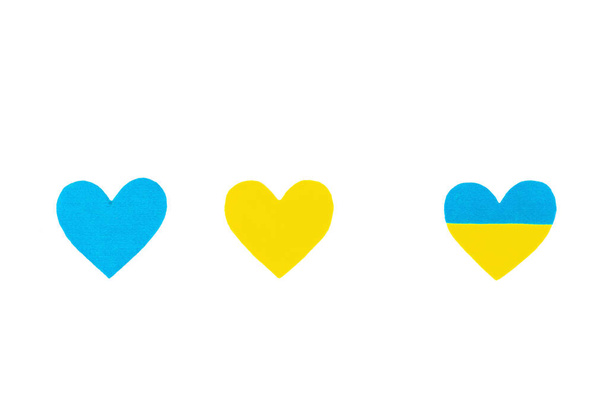 Сердце в цветах украинского флага. Прекратить военную концепцию. Сердце изолировано на белом фоне. Плоская постель, место для текста, макета, искушения, вид сверху - Фото, изображение