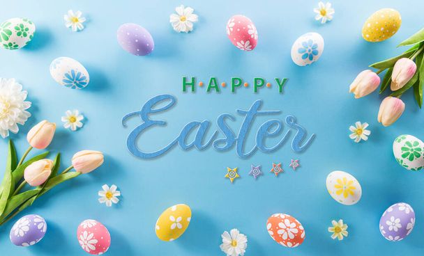 Joyeux Pâques ! oeufs de Pâques colorés avec fleur et le texte sur fond bleu pastel. - Photo, image