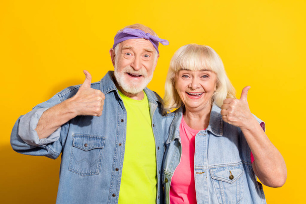 Photo of sweet retired husband wife wear jeans clothes showing thumb up isolated yellow color background - Fotografie, Obrázek
