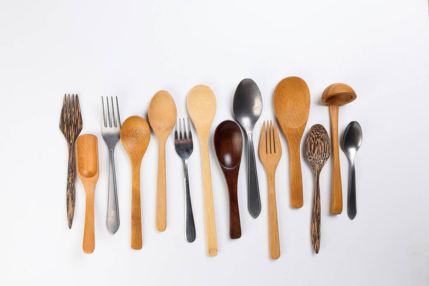 Разнообразие деревянных металлических пластиковых ложек кухонных принадлежностей на белом фоне - Фото, изображение