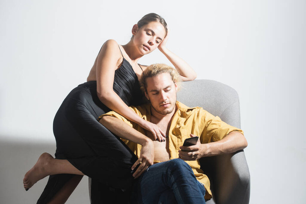 Fashion elegant stylish couple in love looking on each other with pleasure. Sensual woman with her boyfriend posing on gray studio background. Trendy look. - Valokuva, kuva