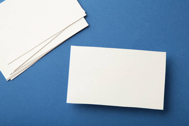 Blank white business cards on blue paper background. Mockup for branding identity. Template for graphic designers portfolios. - Фото, зображення