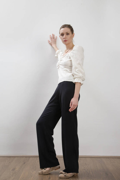 Female model wearing simple casual black and white linen outfit. Studio shot. - Фото, изображение