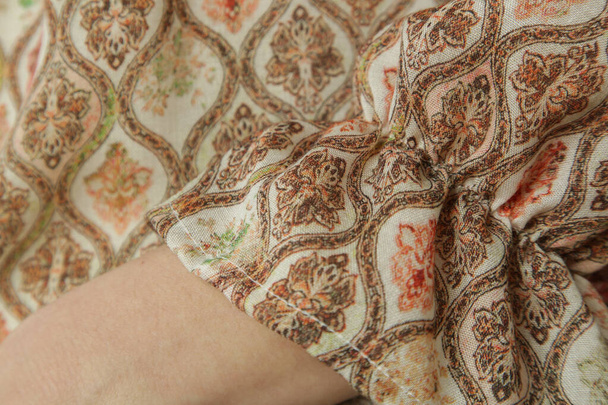 Close up of woman in textured linen blouse with brownish geometric print - Photo, Image