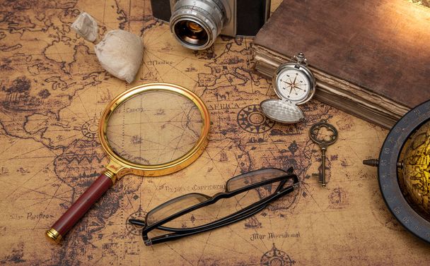 Concepto de viaje vintage que se muestra con mapa antiguo y magificar vidrio, brújula de bolsillo. - Foto, Imagen