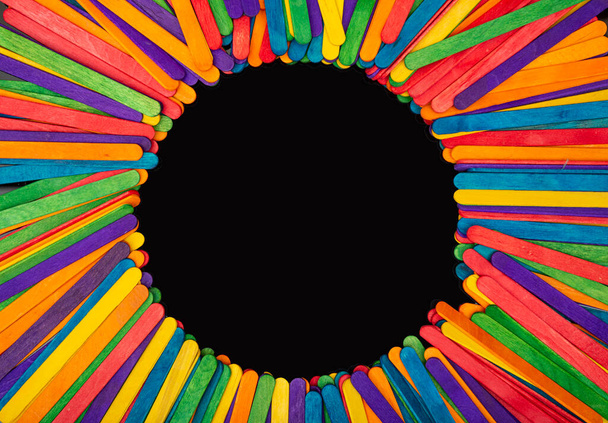 Bastoncini di legno multicolore con cerchio per copia su banner nero. - Foto, immagini